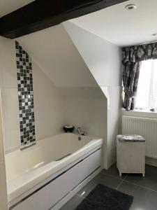 baño blanco con bañera y ventana en Reynolds Farm Guesthouse en Canterbury