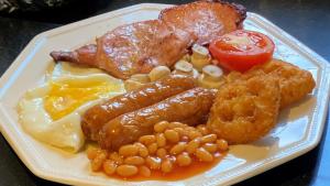 ein Frühstücksteller mit Eiern, Speck, Bohnen und Tomaten in der Unterkunft Reynolds Farm Guesthouse in Canterbury