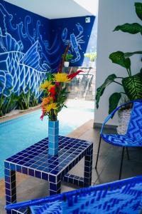 un vase avec des fleurs sur une table à côté d'une piscine dans l'établissement Hotel Casa Luna, à Cúcuta