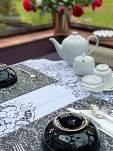 einen Tisch mit einem schwarzen und weißen Tischtuch und einer Teekanne in der Unterkunft Reynolds Farm Guesthouse in Canterbury