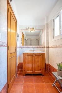 uma casa de banho com um lavatório e um espelho em Fabuloso ático, con amplia terraza em El Médano