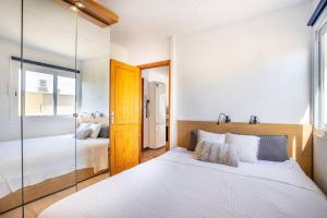 um quarto com uma grande cama branca e um espelho em Fabuloso ático, con amplia terraza em El Médano