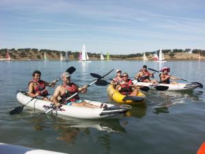 um grupo de pessoas de caiaque num lago com veleiros em A Janela do Alentejo em Campinho