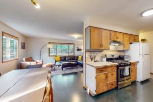 una cucina e un soggiorno con frigorifero e tavolo di Woodland Wonder a Sandpoint