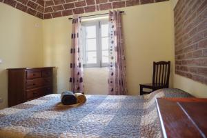 a bedroom with a bed with a dresser and a window at A Janela do Alentejo in Campinho