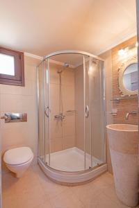 a bathroom with a shower with a toilet and a sink at Filigrana Villa Lindos in Lindos