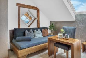 a living room with a blue couch and a table at GIRLINGGUT Schlafen Starten Salzburg in Elixhausen