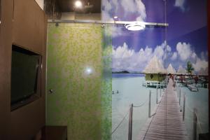a bathroom with a shower with a painting of a beach at Hotel Shivam Palace 1 Km from Railway Station 1 Km from Bus Stand in Ajmer