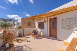 a patio with a door and a table and chairs at Filigrana Villa Lindos in Lindos