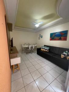 - un salon avec un canapé noir et une table dans l'établissement Caldas Novas Ecologic Park Thermas Apartamento, à Caldas Novas