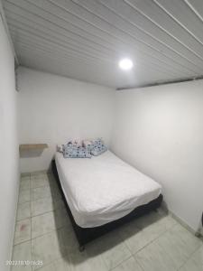 1 dormitorio pequeño con 1 cama en una pared blanca en Hermoso apartamento independiente para pareja, en Villavicencio