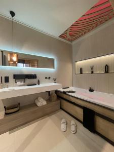 uma grande casa de banho com banheira e lavatório em Host Inn Le Lumiere SPA & CINÉMA em Lyon