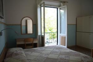 リド・ディ・カマイオーレにあるHotel Ornellaのベッドルーム1室(ベッド1台、窓、デスク付)