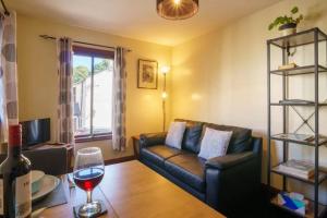 a living room with a couch and a glass of wine at Ground Floor 1 Bed Apartment with Twin/King option in Broughton in Furness