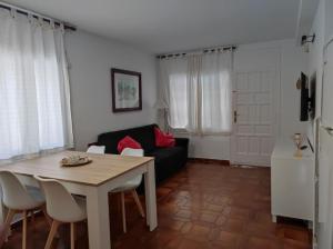 un soggiorno con tavolo e divano nero di Apartament familiar tranquil a Platja d'Aro a Platja  d'Aro