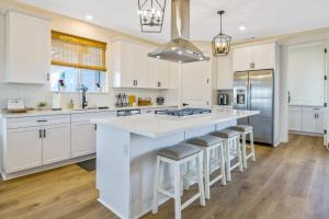 a kitchen with white cabinets and a large island with bar stools at Light on the Hill in Paso Robles