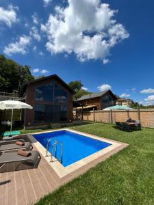 a swimming pool in a yard with a house at Woodlodge Country Sapanca in Sapanca