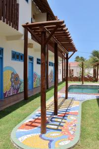 普里亞的住宿－MAKTUB PREA HOSTEL，一座房子边的游泳池,上面有绘画作品