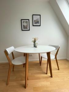 una mesa con 2 sillas y una mesa y sillas blancas en Oidahome - Penthouse Apartment - contactless Self-Check-IN, en Viena
