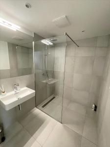y baño con ducha acristalada y lavamanos. en Oidahome - Penthouse Apartment - contactless Self-Check-IN, en Viena