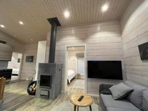 ein Wohnzimmer mit einem Sofa und einem Kamin in der Unterkunft Villa Paadar in Inari