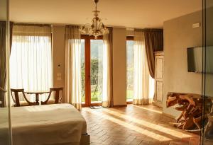 sypialnia z łóżkiem, stołem i telewizorem w obiekcie Borgo I Tre Baroni - Spa Suites & Resort w mieście Poppi +172 zdjęcia