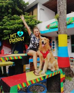 une jeune fille assise sur une structure de jeu avec un chien dans l'établissement Posada Cultural Bahia Sonora, à San Andrés