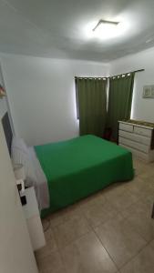 a bedroom with a green bed and a dresser at Posta del Rio in San José