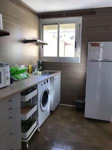 y cocina con lavadora y nevera. en Apartamento cuatro vientos con wifi para trabajar, en Navàs