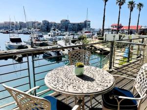 a table and chairs on a balcony with a marina at Port Edge - Ships Bell, Port St Francis Bay in St Francis Bay