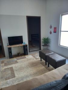 a living room with a flat screen tv and a couch at Casa Ana in Dourados