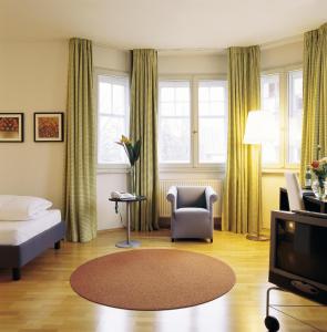 sala de estar con cama y TV en Seeresidenz Alte Post, en Seeshaupt