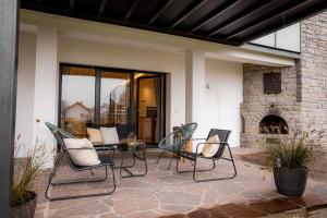 a patio with chairs and a table and a fireplace at Servus Apartments Premium in Vilshofen an der Donau