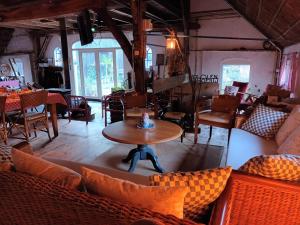 a room with couches and a table and chairs at Hoeve Op Vollenhof in Wezep