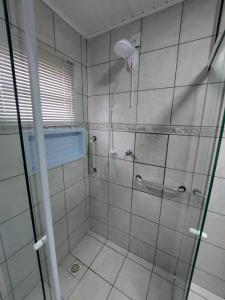 a bathroom with a shower with a glass door at Pousada Caminho do Altos in Bom Jardim da Serra