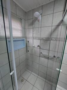 une salle de bain avec une douche avec une porte vitrée dans l'établissement Pousada Caminho do Altos, à Bom Jardim da Serra 16 autres photos