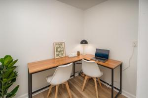 布恩的住宿－The Wanderer Guesthouse，一张带笔记本电脑和两把白色椅子的桌子