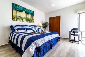 a bedroom with a blue and white bed and a desk at Milan San Marino in Tijuana