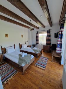 two beds in a room with wooden floors at Hanul Almaș in Deva