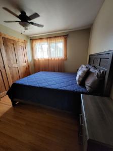 - une chambre avec un lit et un ventilateur de plafond dans l'établissement Feel at home, Country style family house., à Magrath