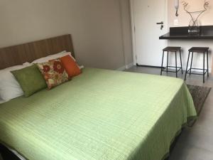 um quarto com uma cama com um cobertor verde em Fantástico STUDIO DIVISA COPACABANA IPANEMA REFORMADO E DECORADO no Rio de Janeiro