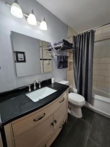 La salle de bains est pourvue d'un lavabo, de toilettes et d'un miroir. dans l'établissement Feel at home, Country style family house., à Magrath