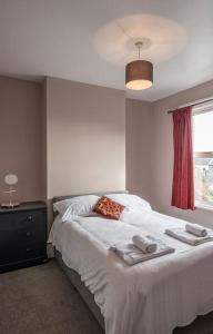a bedroom with a white bed with towels on it at Picton House: Charming 3 bed property in quiet location in Ramsgate