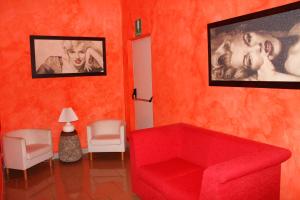 a red living room with a red couch and pictures at Hotel Residence Charly in Lido di Fermo