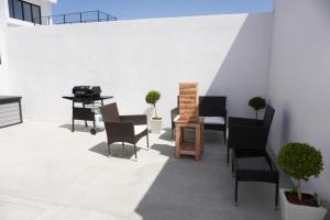 een patio met stoelen, een tafel en een grill bij Milan San Marino in Tijuana
