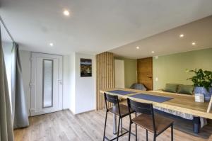 a room with a table and chairs and a bed at Studio lumineux en rez-de-jardin situé sur la route des vins d'Alsace in Ammerschwihr