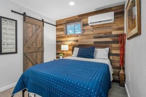 a bedroom with a blue bed and a wooden wall at South Tampa Central Location Efficiency Suite in Tampa