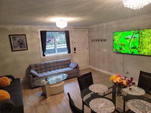 uma sala de estar com um sofá e uma televisão de ecrã plano em Oscar INN & 2bd Family Suite or Private Room em Abbotsford