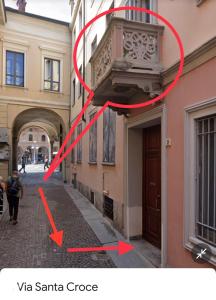 eine Person, die eine Straße entlang geht, neben einem Gebäude in der Unterkunft Emma Home adiacente alla Piazza Ducale in Vigevano