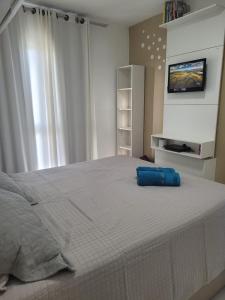 a bedroom with a large bed with a blue pillow on it at Muro Alto condomínio CLUBE AP 411 in Porto De Galinhas
